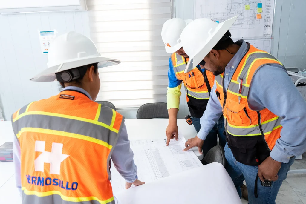 Tres arquitectos de Grupo Hermosillo  analizando los el plan de construcción