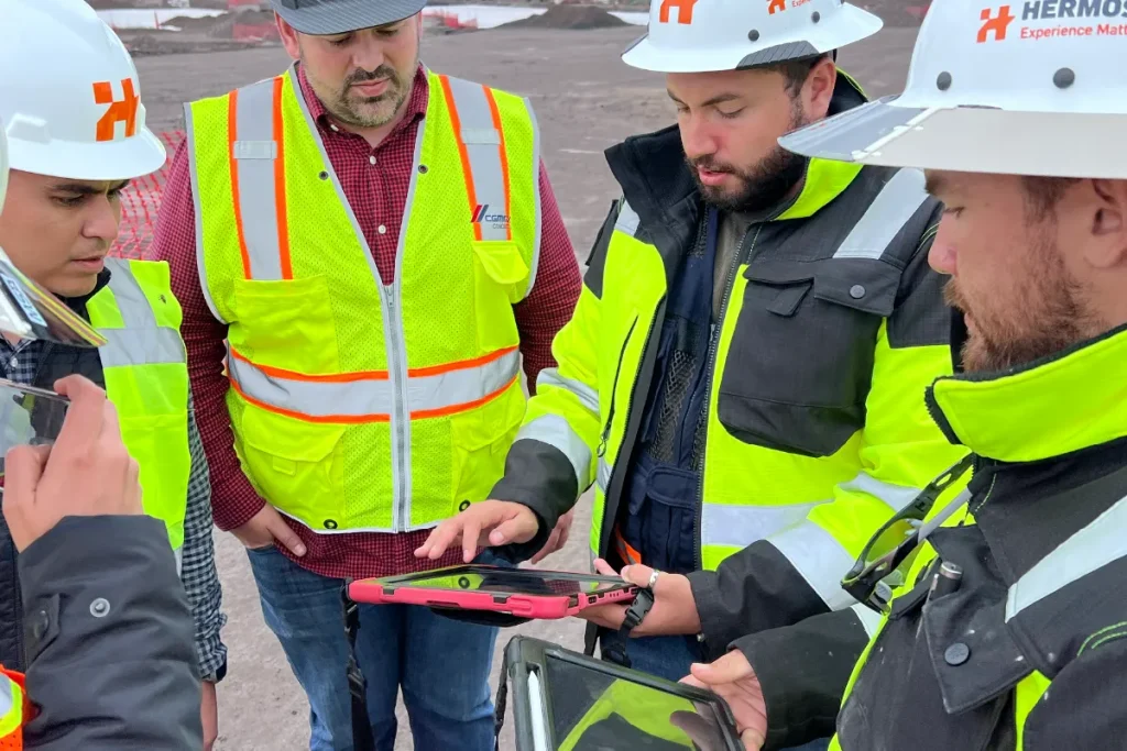 work team at a construction site using a  tablet with bim technology